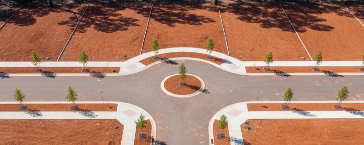 Aerial view of aerial of a new estate cul-de-sac, vacant graded lots around a turning circle, no houses